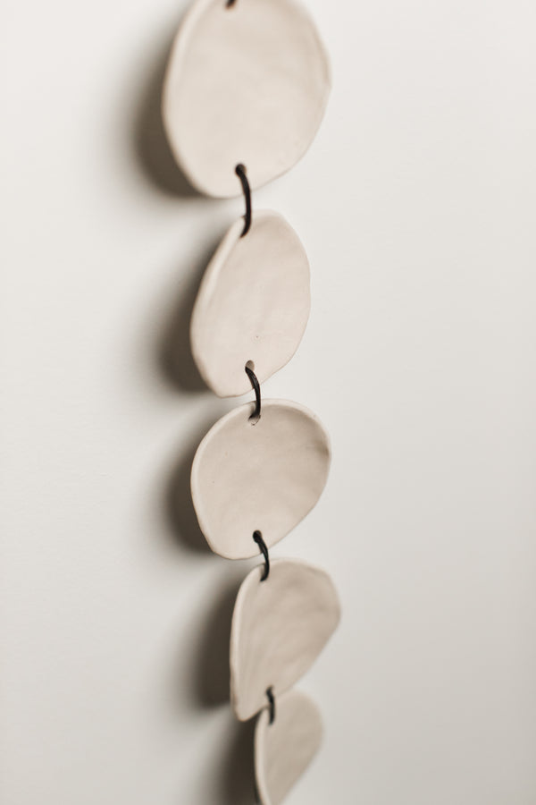 Hand-pinched ceramic circles strung with leather cord